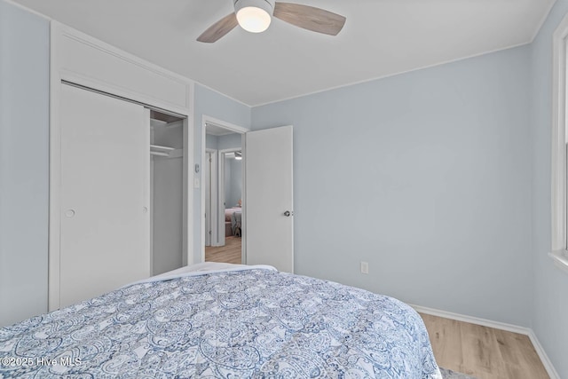 bedroom featuring a closet, baseboards, light wood-style floors, and ceiling fan