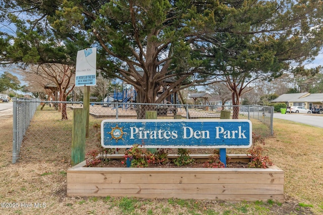 community / neighborhood sign with fence and a lawn