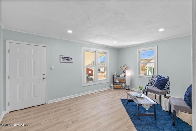 living area with recessed lighting, baseboards, light wood-style floors, and crown molding