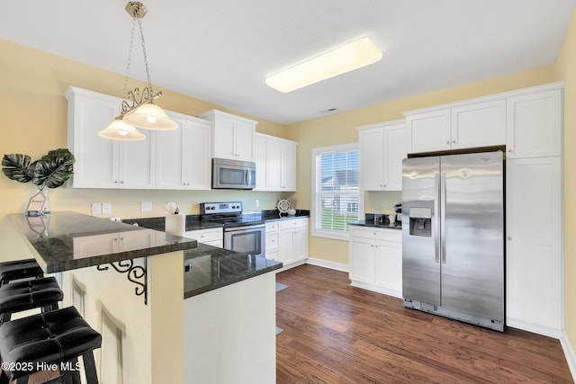 kitchen featuring white cabinets, a peninsula, and stainless steel appliances