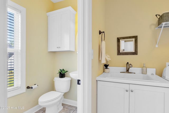 bathroom featuring toilet, tile patterned floors, plenty of natural light, and baseboards