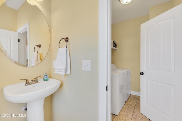 bathroom with tile patterned floors, baseboards, and washer and clothes dryer