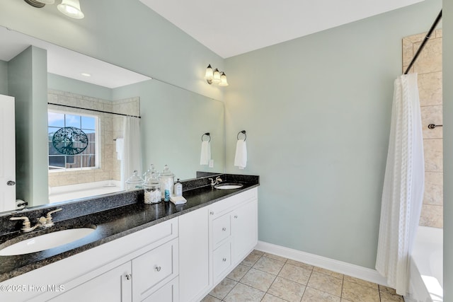 bathroom with tile patterned flooring, double vanity, baseboards, and a sink