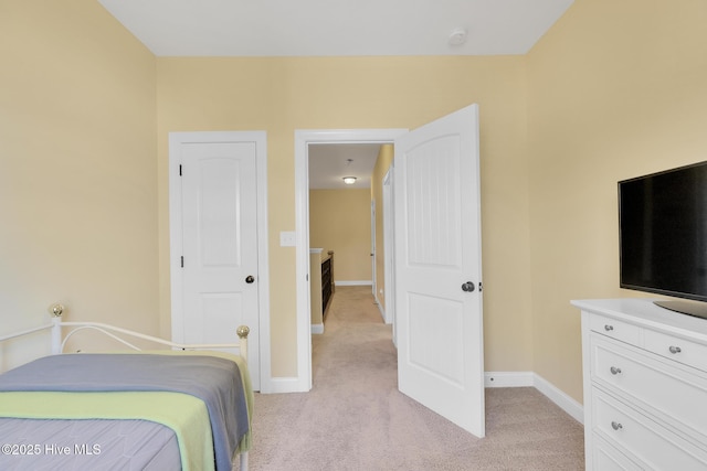 bedroom featuring baseboards and light carpet