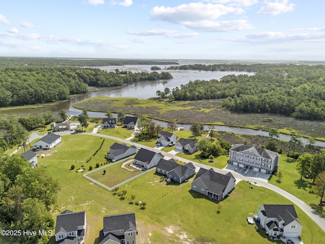 drone / aerial view with a residential view, a water view, and a view of trees