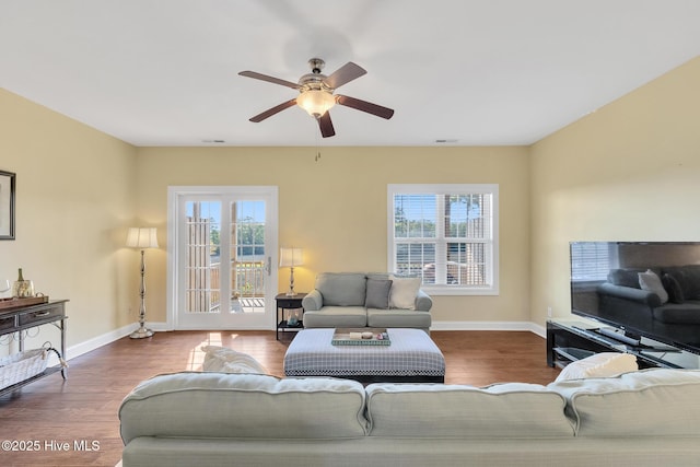 living room with visible vents, baseboards, a healthy amount of sunlight, and wood finished floors