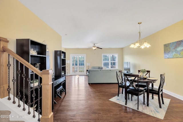 dining room featuring ceiling fan with notable chandelier, stairs, baseboards, and dark wood-style flooring