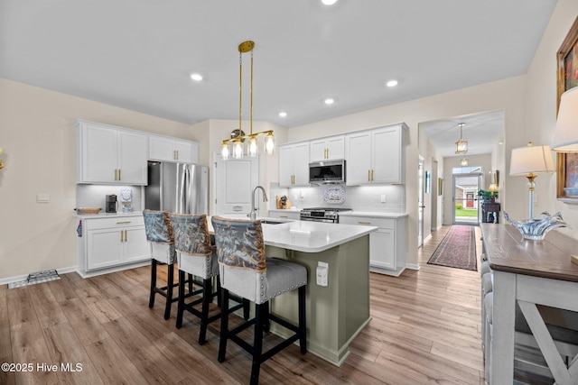 400 Frida Rd, New Bern, NC 28560 - kitchen with stainless steel appliances, light countertops, a sink, light wood-style floors, and decorative backsplash