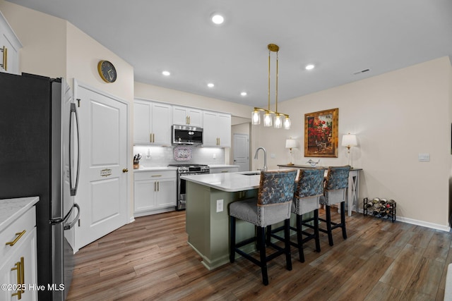 400 Frida Rd, New Bern, NC 28560 - kitchen featuring stainless steel appliances, a sink, wood finished floors, an island with sink, and white cabinets