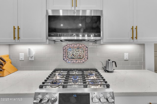 400 Frida Rd, New Bern, NC 28560 - kitchen view of stainless steel microwave, decorative backsplash, light stone countertops, and white cabinets