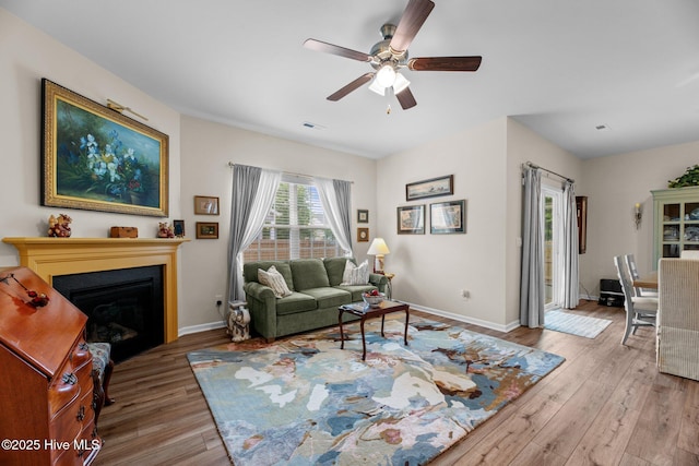 400 Frida Rd, New Bern, NC 28560 - living area with wood finished floors, ceiling fan, a glass covered fireplace, and baseboards