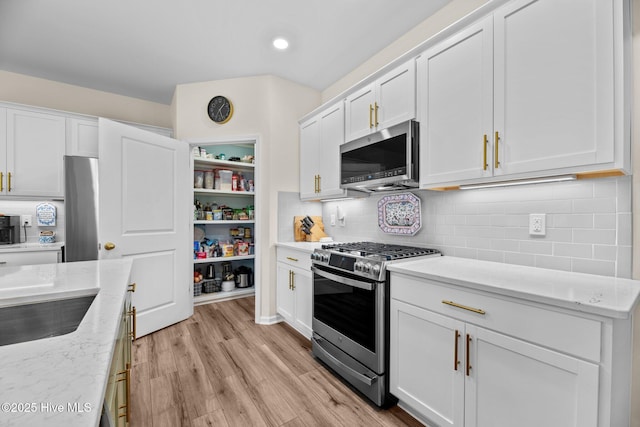 400 Frida Rd, New Bern, NC 28560 - kitchen with appliances with stainless steel finishes, white cabinets, light wood-style floors, decorative backsplash, and recessed lighting