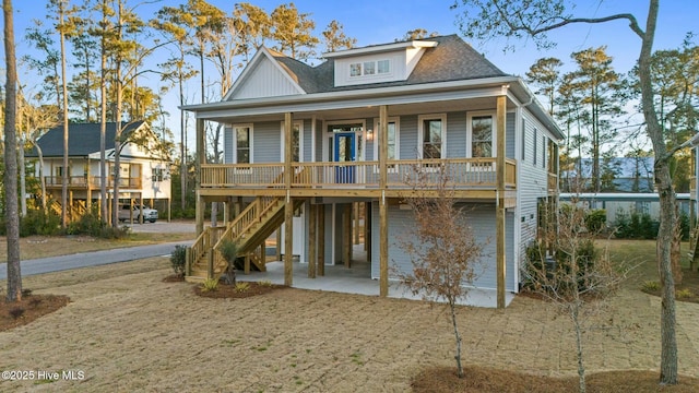 view of front of home with a patio area, stairway, covered porch, and roof with shingles