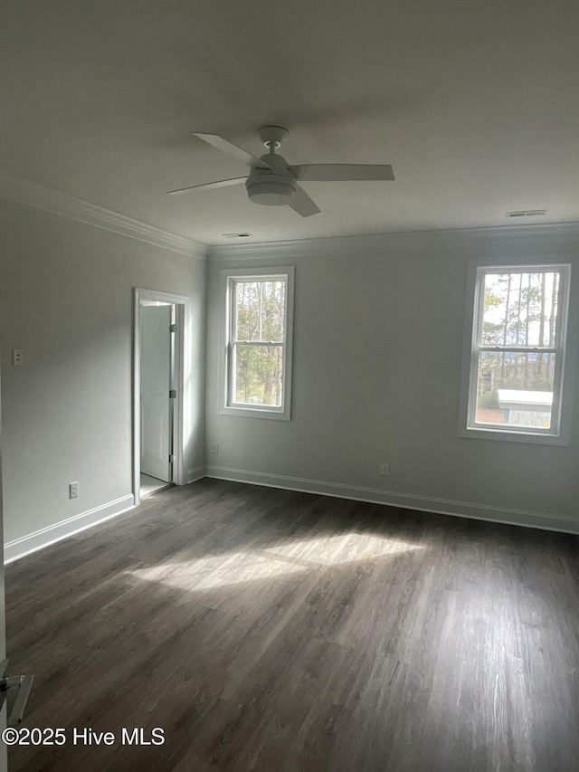 empty room with a ceiling fan, crown molding, baseboards, and dark wood-style flooring