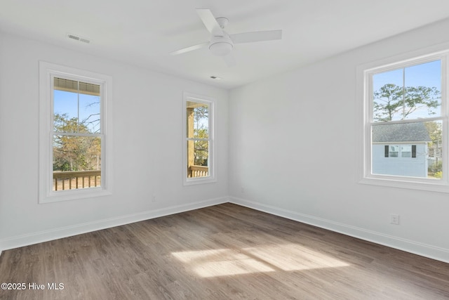 7105 E Yacht Dr, Oak Island, NC 28465 - unfurnished room featuring wood finished floors, baseboards, visible vents, and a wealth of natural light