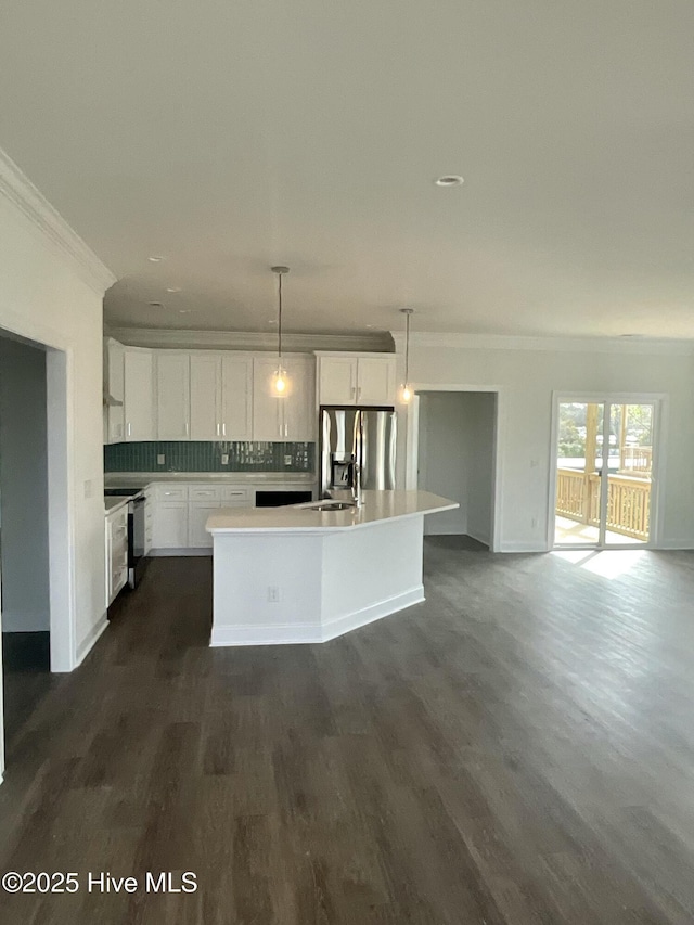 kitchen featuring dark wood-type flooring, ornamental molding, backsplash, stainless steel fridge, and light countertops