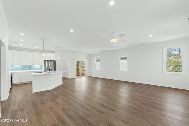7105 E Yacht Dr, Oak Island, NC 28465 - unfurnished living room featuring dark wood finished floors, ceiling fan, and ornamental molding