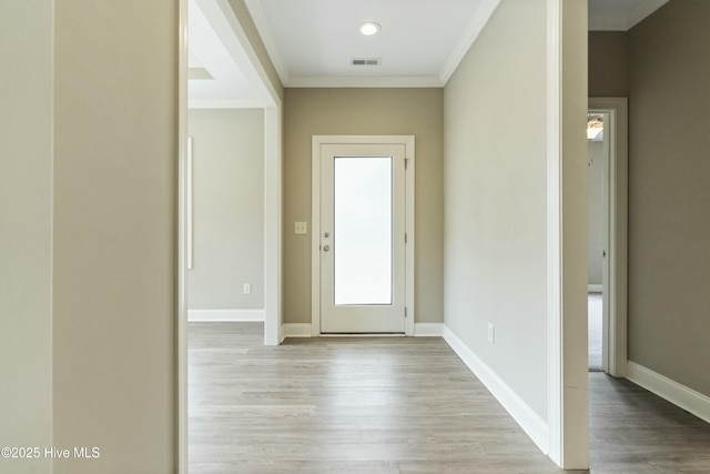 interior space with baseboards, light wood-style floors, visible vents, and ornamental molding