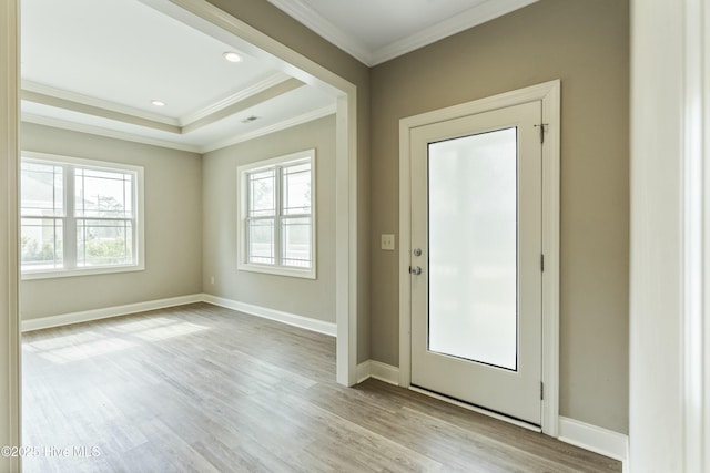 doorway with baseboards, a healthy amount of sunlight, light wood-style flooring, and ornamental molding