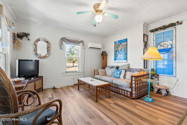 living room with ornamental molding, an AC wall unit, ceiling fan, and wood finished floors