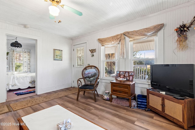 sitting room featuring a wealth of natural light, crown molding, and wood finished floors