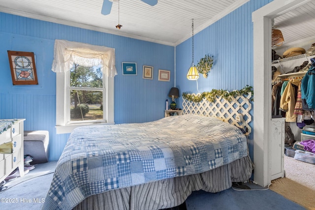 bedroom with a ceiling fan, carpet, a walk in closet, crown molding, and a closet