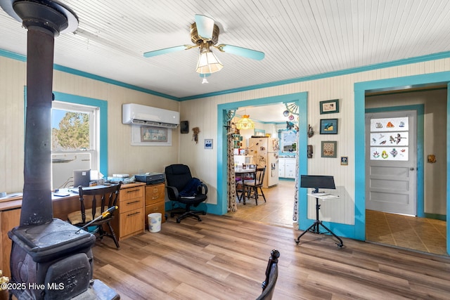 office featuring a ceiling fan, a wall unit AC, ornamental molding, and light wood finished floors