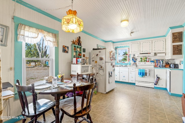 dining room featuring light floors and crown molding