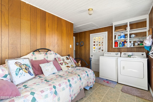 bedroom featuring wooden walls and separate washer and dryer