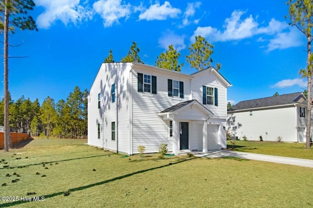 traditional-style house featuring a front yard, concrete driveway, and an attached garage