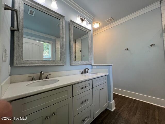 full bath featuring ornamental molding, visible vents, and a sink