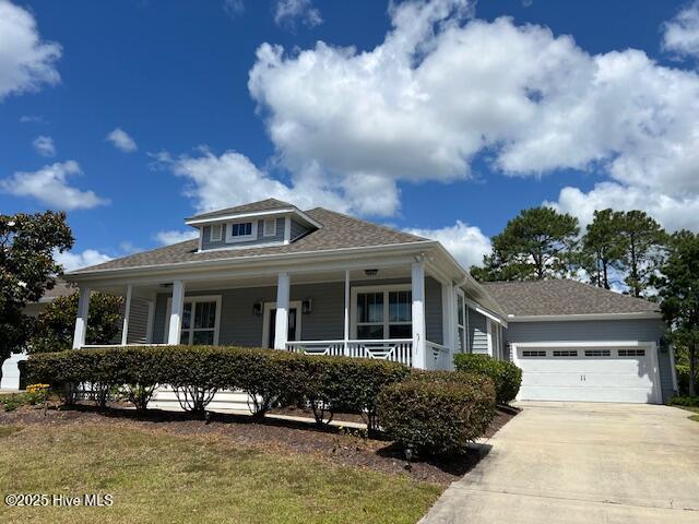 view of front facade featuring a porch, concrete driveway, and a garage