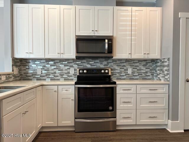 kitchen featuring decorative backsplash, appliances with stainless steel finishes, white cabinets, and light countertops