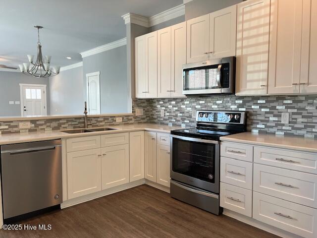 kitchen with decorative backsplash, light countertops, appliances with stainless steel finishes, and a sink