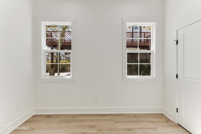 unfurnished room with light wood-type flooring and baseboards