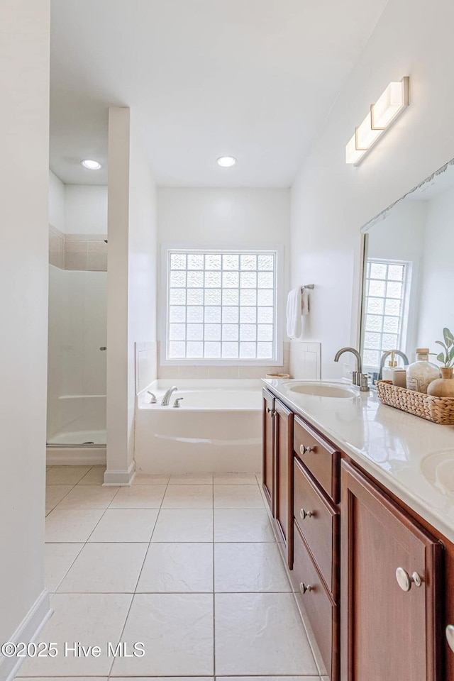 bathroom featuring tile patterned floors, a garden tub, a sink, and double vanity