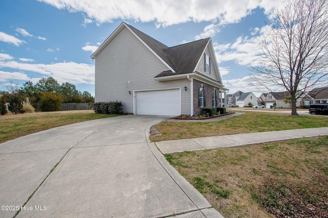 view of side of home with a garage, a yard, brick siding, and concrete driveway