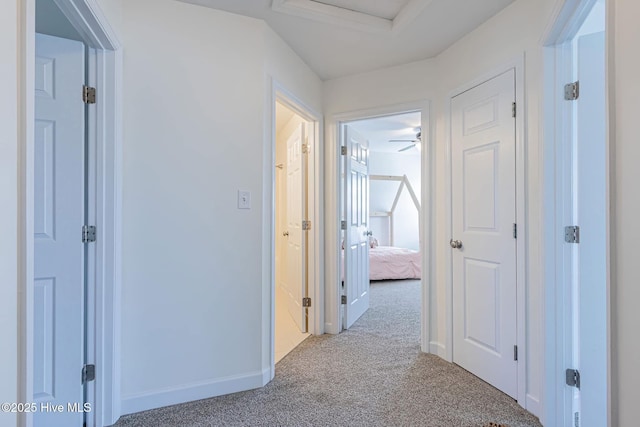 hallway featuring carpet floors and baseboards