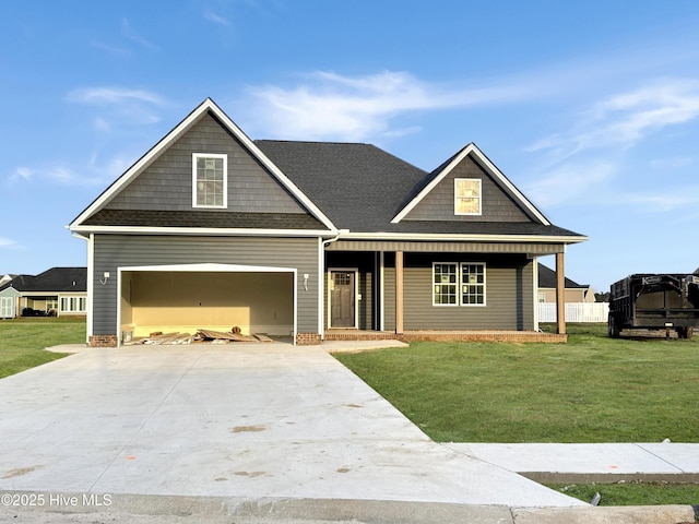 craftsman house with a front yard, covered porch, roof with shingles, and driveway