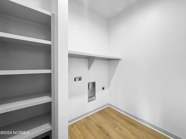 laundry area with washer hookup, electric dryer hookup, wood finished floors, laundry area, and baseboards