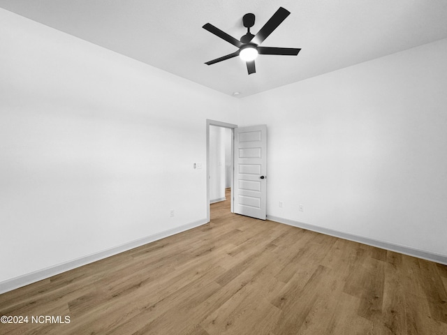 spare room with light wood-style floors, baseboards, and a ceiling fan