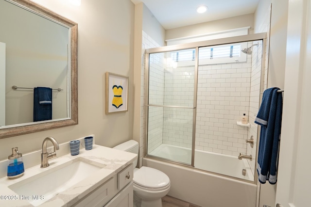 full bath with toilet, bath / shower combo with glass door, and vanity