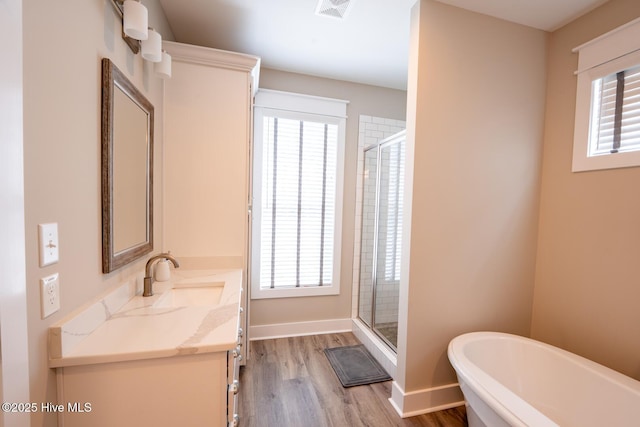 full bath featuring a soaking tub, visible vents, a stall shower, vanity, and wood finished floors