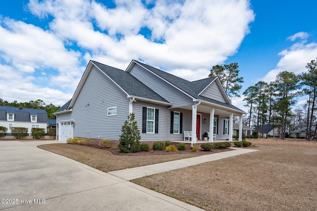 view of front of property with a porch, concrete driveway, roof with shingles, and a garage