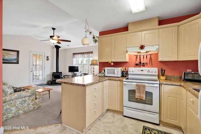 kitchen with a peninsula, white appliances, under cabinet range hood, open floor plan, and a wood stove