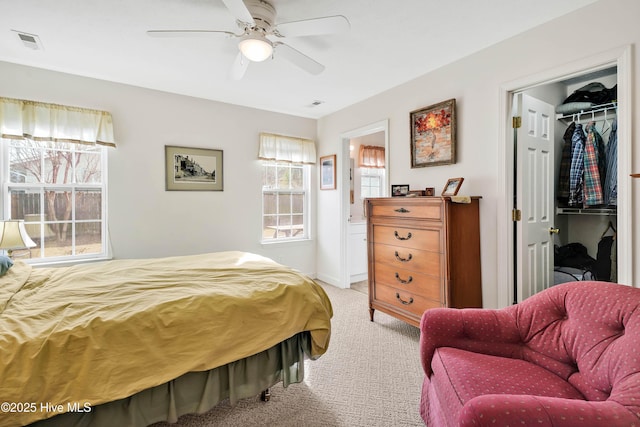 bedroom featuring a spacious closet, a closet, light colored carpet, and visible vents