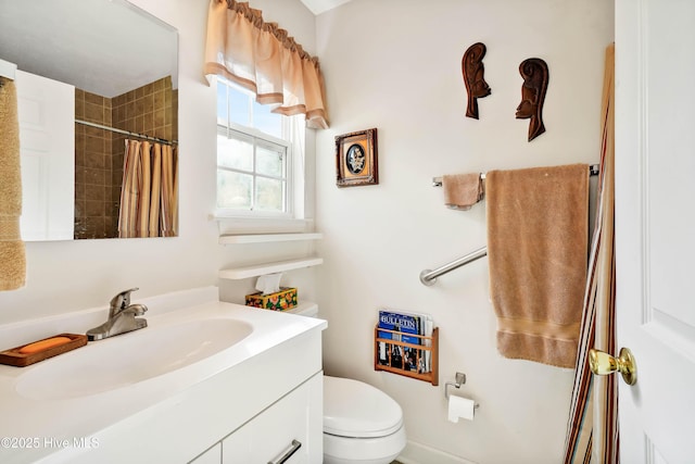 bathroom featuring toilet, tiled shower, and vanity