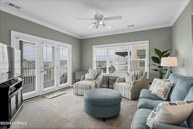 carpeted living room with a ceiling fan, visible vents, and crown molding