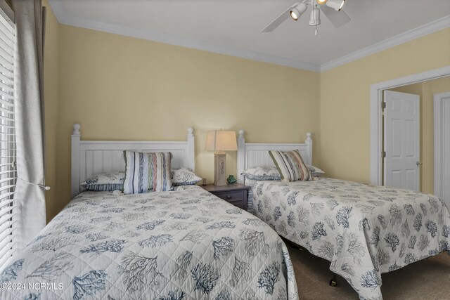 carpeted bedroom with ceiling fan and ornamental molding