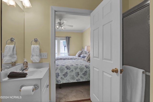 carpeted bedroom with ceiling fan, ornamental molding, and a sink